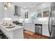 Bright white kitchen featuring stainless steel appliances, white cabinetry, and a contrasting wood floor at 4 Addison St, Charleston, SC 29403