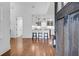 Open-concept living space showcasing hardwood floors and a modern kitchen beyond the dark wood front door at 4 Addison St, Charleston, SC 29403