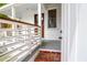 Inviting front porch featuring white railings, a stained wood door and a brick landing at 4 Addison St, Charleston, SC 29403