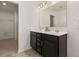 Bathroom with double sink vanity, dark cabinets, and a doorway leading to the walk in closet at 433 Thoroughbred Dr, Moncks Corner, SC 29461