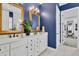 Bathroom features a white double sink vanity, gold framed mirrors, with blue walls at 440 Four Seasons Blvd, Summerville, SC 29486