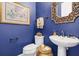 Elegant powder room featuring blue walls, ornate mirror, pedestal sink, and decorative accents at 440 Four Seasons Blvd, Summerville, SC 29486
