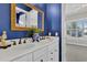 The bathroom features a double sink with a marble countertop, gold framed mirror and blue accent wall at 440 Four Seasons Blvd, Summerville, SC 29486