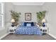 This bedroom features a bed with blue and white patterns, two bedside tables, and charming bamboo plants at 440 Four Seasons Blvd, Summerville, SC 29486