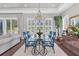 Open-concept dining area with a glass table, six patterned chairs, a chandelier, and ample natural light at 440 Four Seasons Blvd, Summerville, SC 29486