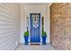 Stylish front door with decorative wreath, flanked by manicured topiaries and beautiful stone accents at 440 Four Seasons Blvd, Summerville, SC 29486