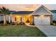 Exterior of a charming single-Gathering home with a stone facade, well-kept lawn, and a cozy front porch at dusk at 440 Four Seasons Blvd, Summerville, SC 29486