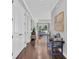 Long hallway with hardwood floors, white doors, and a glimpse into a bright, open living space at 440 Four Seasons Blvd, Summerville, SC 29486