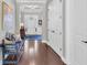 Long hallway with hardwood floors, white doors, and a glimpse into a bright, open living space at 440 Four Seasons Blvd, Summerville, SC 29486