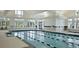 Well-lit indoor pool with dividing lane markers and nearby jacuzzi. The pool is surrounded by large windows at 440 Four Seasons Blvd, Summerville, SC 29486