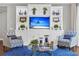Living room with a large white built-in entertainment center, two blue patterned chairs and a glass coffee table at 440 Four Seasons Blvd, Summerville, SC 29486