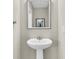 Elegant pedestal sink with sleek fixtures, illuminated by the recessed lighting and a stylish mirror at 4429 Avery Ave, North Charleston, SC 29405