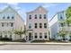 Charming three-story home with a pastel pink exterior and manicured front yard, flanked by similar homes at 4429 Avery Ave, North Charleston, SC 29405