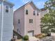 Rear view of the three-story pink home showing a convenient garage and well-kept backyard at 4429 Avery Ave, North Charleston, SC 29405