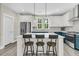 Bright kitchen with island, stainless appliances, two-toned cabinets, barstool seating and natural light at 4429 Avery Ave, North Charleston, SC 29405