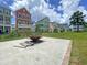 Community space boasts a firepit seating area surrounded by a lush green lawn and colorful townhomes at 4429 Avery Ave, North Charleston, SC 29405