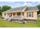 A charming home with a quaint front porch, red shutters and brick base with professional landscaping at 449 Mary Lou Ln, Moncks Corner, SC 29461