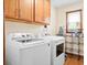 Functional laundry room with modern white appliances, wooden cabinets, and a window for natural light at 449 Mary Lou Ln, Moncks Corner, SC 29461