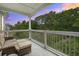 Relaxing covered balcony with comfortable seating and a scenic view of lush greenery and sunset at 45 Sycamore Ave # 1532, Charleston, SC 29407