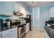 Modern kitchen with stainless steel appliances, light blue walls, and black countertops at 45 Sycamore Ave # 1532, Charleston, SC 29407