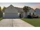 Inviting home exterior with a well-manicured lawn, driveway, palm tree, and a two-car garage at 462 Maple Oak Ln, Charleston, SC 29414