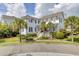 Inviting two-story home with white siding, a front porch, palm trees, and lush landscaping, offering classic curb appeal at 509 Gilberts Lndg, Mount Pleasant, SC 29464