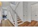 Elegant staircase with hardwood steps, white railings, and wainscoting at 509 Gilberts Lndg, Mount Pleasant, SC 29464