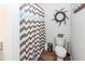 Cozy bathroom featuring a toilet, chevron shower curtain, wood-look floors, and rustic decorative elements at 5153 Celtic Dr, North Charleston, SC 29405