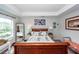 Bright bedroom with a sleigh bed, side tables, decorative lamps, and natural light from the windows at 5153 Celtic Dr, North Charleston, SC 29405