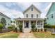 Charming two-story home featuring a welcoming front porch with classic white columns and a neatly landscaped yard at 5153 Celtic Dr, North Charleston, SC 29405