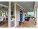 Inviting front porch featuring a cozy seating area, complemented by a bright blue door and stylish decor at 5153 Celtic Dr, North Charleston, SC 29405