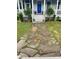 Stone walkway leading to a charming home with a blue door and a welcoming front porch, surrounded by green lawn at 5153 Celtic Dr, North Charleston, SC 29405