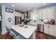 An open kitchen has white cabinets, stainless steel appliances, and a spacious island with chairs at 5153 Celtic Dr, North Charleston, SC 29405