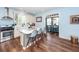 Open kitchen with island, white cabinets, stainless appliances, and hardwood floors leading into the dining area at 5153 Celtic Dr, North Charleston, SC 29405