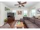 A living room has hardwood floors, a ceiling fan, a large sectional couch, and multiple windows at 5153 Celtic Dr, North Charleston, SC 29405