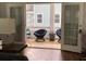 A sunlit patio featuring woven chairs is visible through double french doors from the home's interior at 5153 Celtic Dr, North Charleston, SC 29405