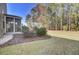Backyard featuring a well-maintained lawn, trees, and an enclosed patio with landscaping at 534 Four Seasons Blvd, Summerville, SC 29486