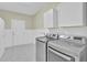 Laundry room with tile floors, white cabinets, wainscoting, and stainless-steel washer and dryer at 534 Four Seasons Blvd, Summerville, SC 29486