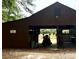 Rustic barn featuring open stalls, a tractor, and ample space for equipment or livestock at 5354 Ceva Dr, Hollywood, SC 29449