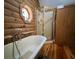 Bathroom with wood walls, free standing tub, glass shower, and stained glass window at 5354 Ceva Dr, Hollywood, SC 29449