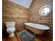 Full bathroom with free standing tub, stained glass window, toilet, and wood floors at 5354 Ceva Dr, Hollywood, SC 29449