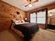 Comfortable bedroom with wood-paneled walls, ceiling fan, carpet and a large window at 5354 Ceva Dr, Hollywood, SC 29449