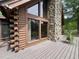 Charming log cabin exterior featuring a stone chimney and spacious wooden deck at 5354 Ceva Dr, Hollywood, SC 29449