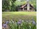 Log cabin home with stone chimney surrounded by a large yard and mature trees at 5354 Ceva Dr, Hollywood, SC 29449