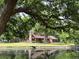 Inviting home featuring an exterior stone chimney, lakeside yard, and deck for relaxing outdoors at 5354 Ceva Dr, Hollywood, SC 29449