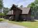 Charming log cabin home with a welcoming porch and lush landscaping, creating a serene atmosphere at 5354 Ceva Dr, Hollywood, SC 29449