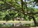 Exterior view of the home featuring a pond, a small dock, mature trees, and a bench at 5354 Ceva Dr, Hollywood, SC 29449
