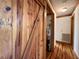 Hallway with hardwood floors and barn door leading to closet with storage at 5354 Ceva Dr, Hollywood, SC 29449
