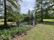 A tranquil pond surrounded by lush greenery and trees, showcasing a peaceful and natural setting at 5354 Ceva Dr, Hollywood, SC 29449