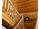 Rustic staircase featuring log railing and wood paneling throughout the house at 5354 Ceva Dr, Hollywood, SC 29449